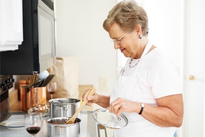 older woman cooking at home body rsc